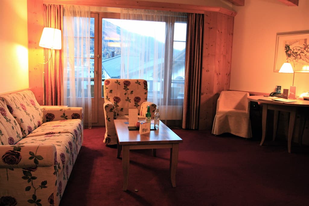 A suite living room at the Waldhuus, with a balcony door onto the valley